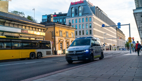 Bild av en väg i ett stadscentrum. På bild en buss och en polisbil.