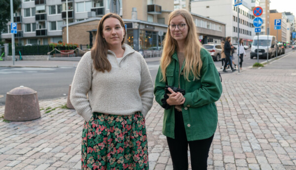 Två unga kvinnor i ett gathörn