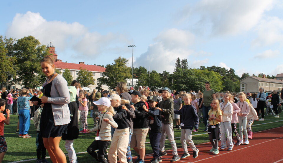 Elever och lärare dansar letkajenkka tillsammans utomhus i Ekenäs. Eleverna har just utlyst skolfred.