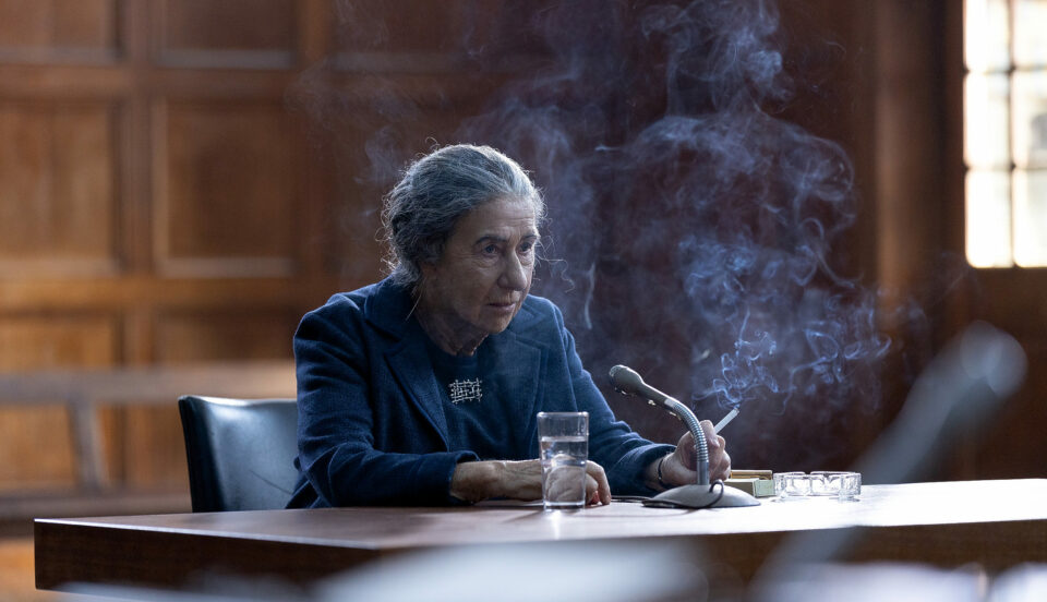 Kvinna röker vid skrivbord.
