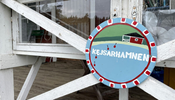 Rund målad tavla med namnet Kejsarhamnen