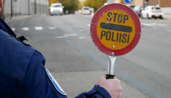 en polis håller i en stoppskylt