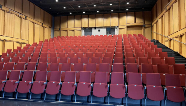Tomt auditorium med 250 röda stolar