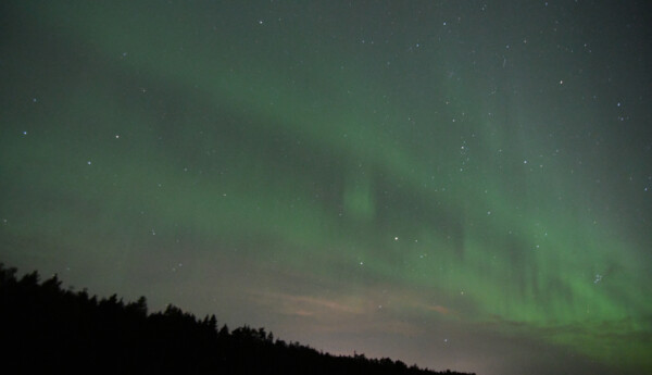 Gröna molnliknande formationer på en kvällshimmel.