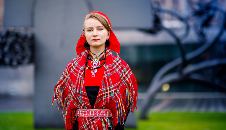 Ung kvinna iklädd en samedräkt (gákti) i rött och svart.