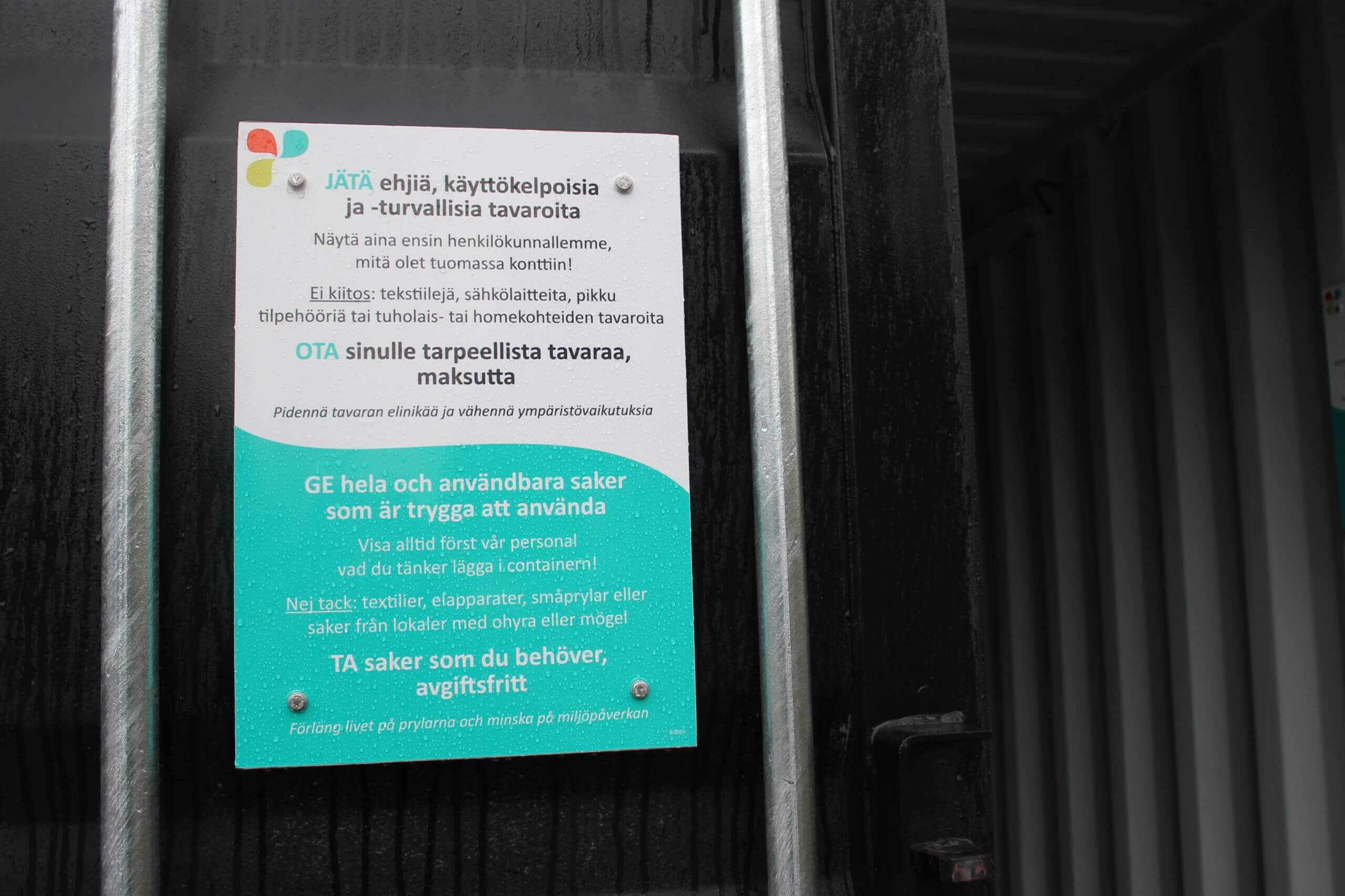 Närbild på en skylt som beskriver reglerna för en ge och ta-container på avfallsstationen i Karis.