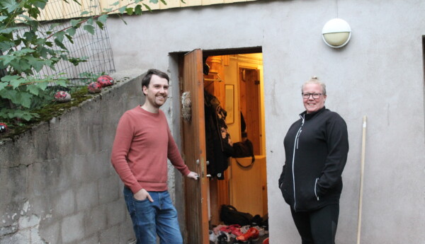 En man håller upp en dörr till en källare i ett hus. En kvinna står bredvid honom och ler. Dörren mannen öppnat är till den nya ungdomsgården i Tenala.