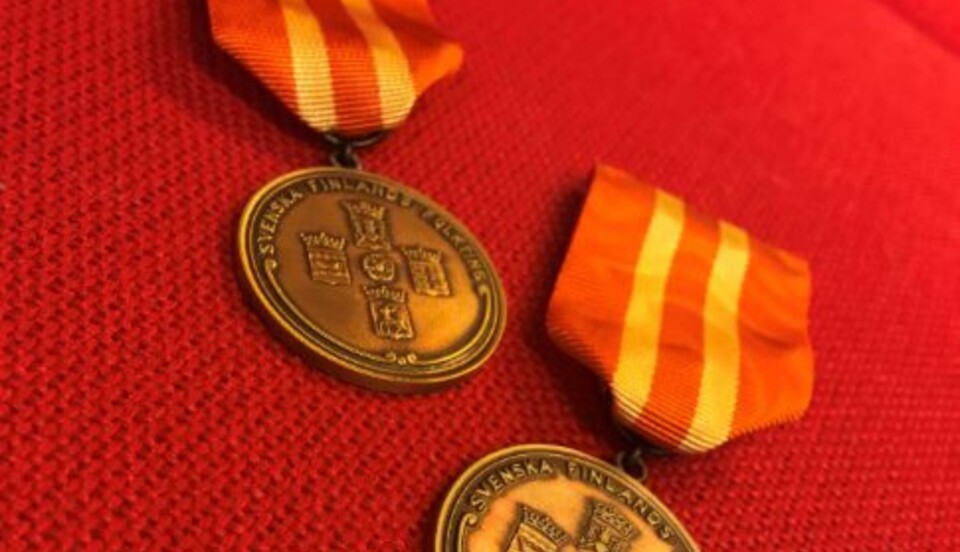 Två medaljer på röd bakgrund