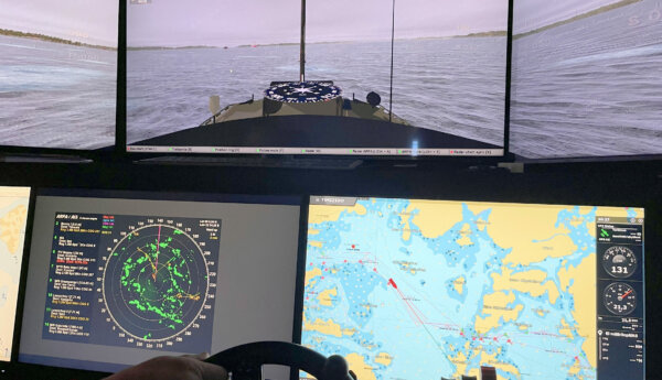 Vy från båtsimulator: sex skärmar (med bland annat sjökort) och en ratt.