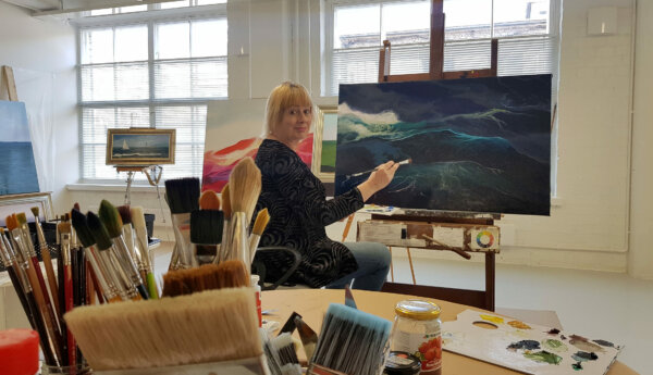 kvinna vid en havsmålning i en ateljé