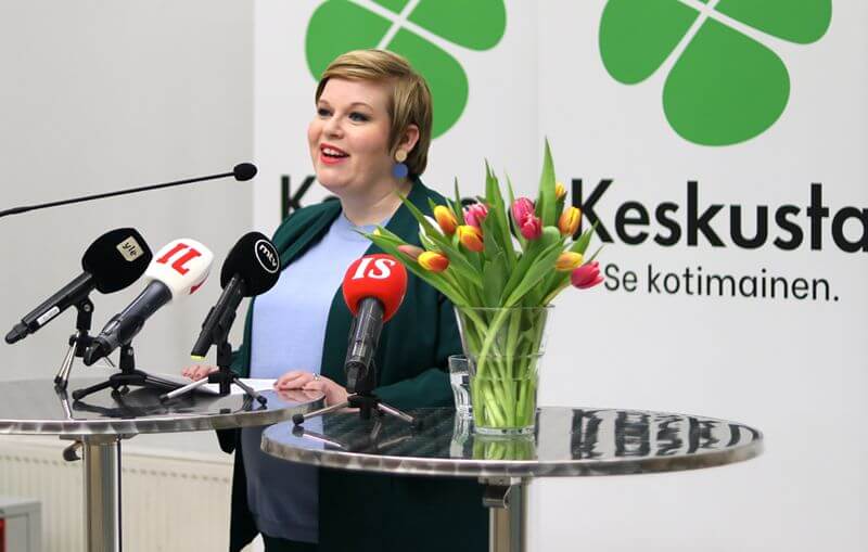 politikerkvinna bakom bord med tulpaner och mikronfoner