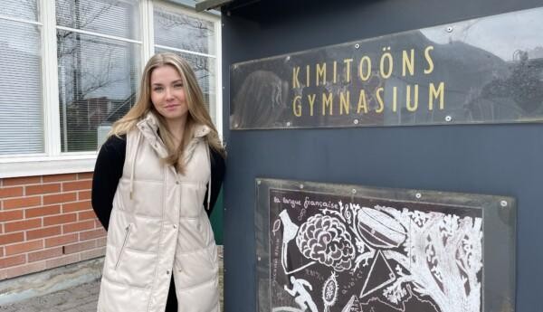 En studerande vid en skylt med texten Kimitoöns gymnasium