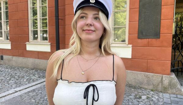 Edith Friis med studentmössan på huvudet framför Katedralskolan i Åbo.