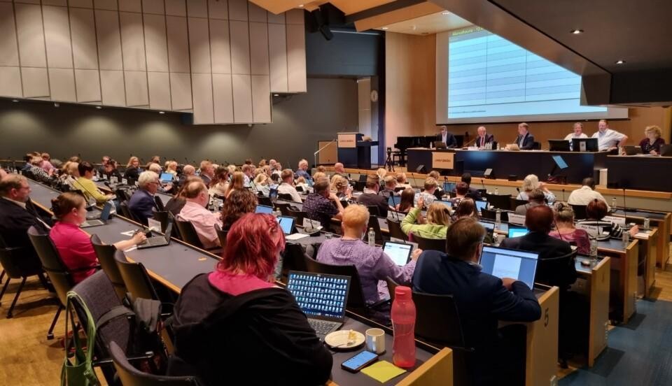 politiker i stort auditorium . fotat snett bakifrån