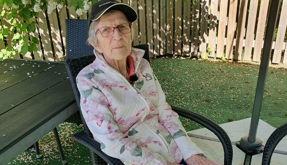 äldre kvinna i en trädgårdsstol utomhus