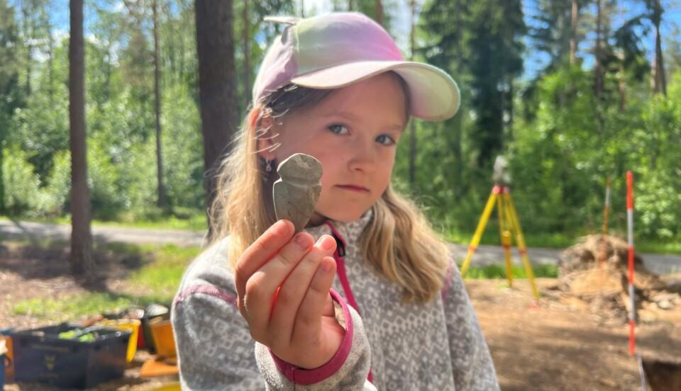 Klaara Huhtamäki visar upp sitt stenåldersfynd.