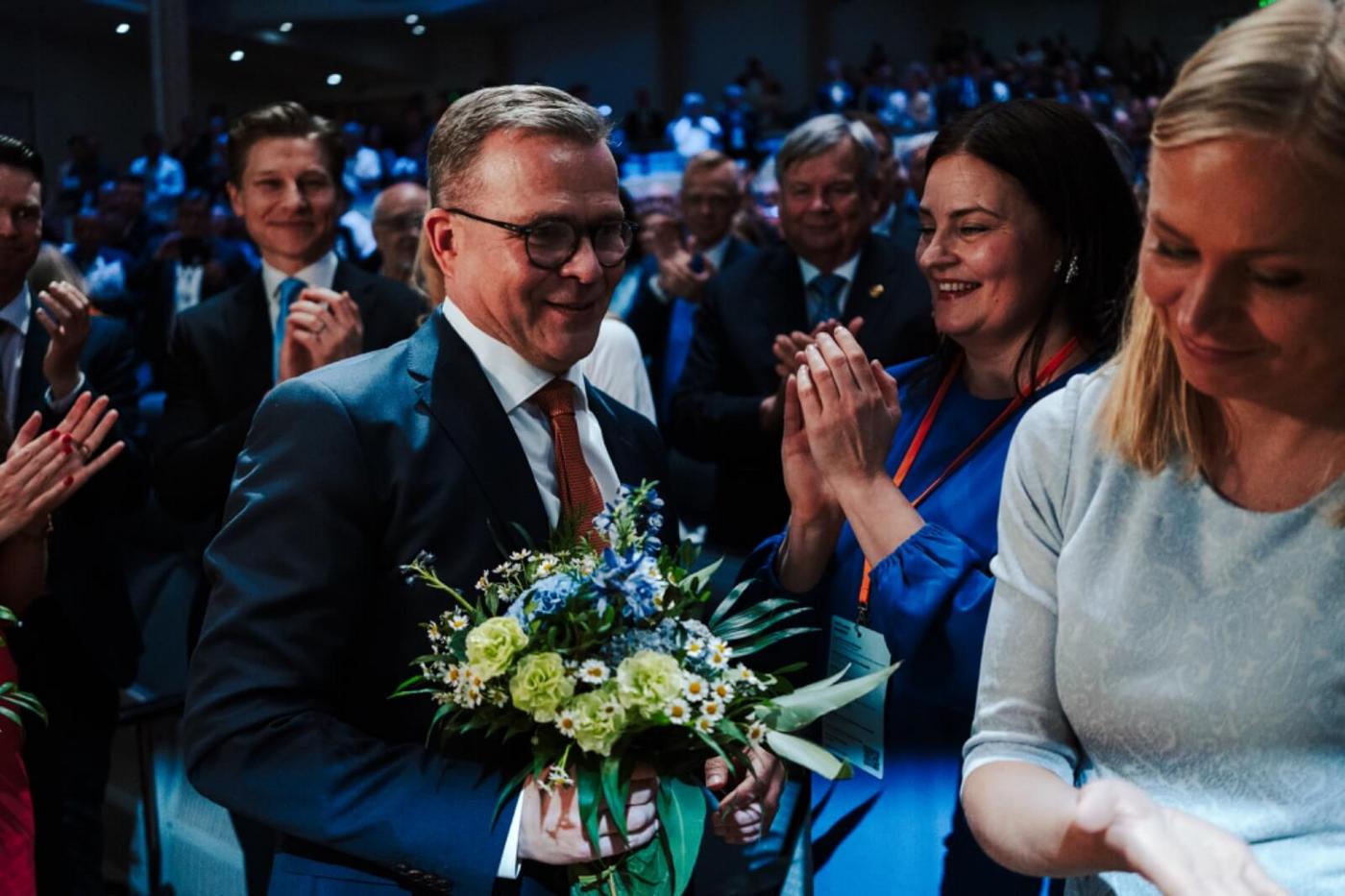 Politikern Petter i Orpo med en blombukett i ett folkhav