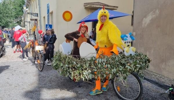 två personer utklädda tillkycklingar och en fågelbocykel