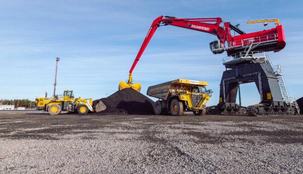 Hjullastare, dumper och grävmaskin vid svart stenkolshög.