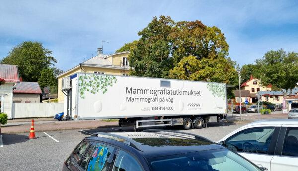 en vit container för mammografiundersökningar står på en parkeringsplats